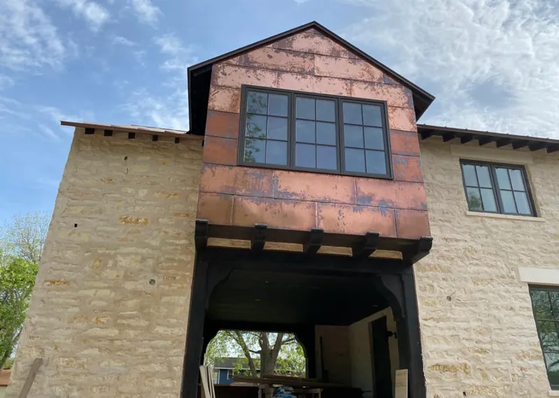 Copper metal panel facade on a stone building for Roof Repair in Yosemite Lakes